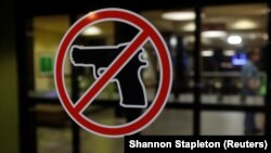 Shenja që ndalon bartjen e armëve e vendosur në një derë - Fotografi ilustruese nga arkivi.  