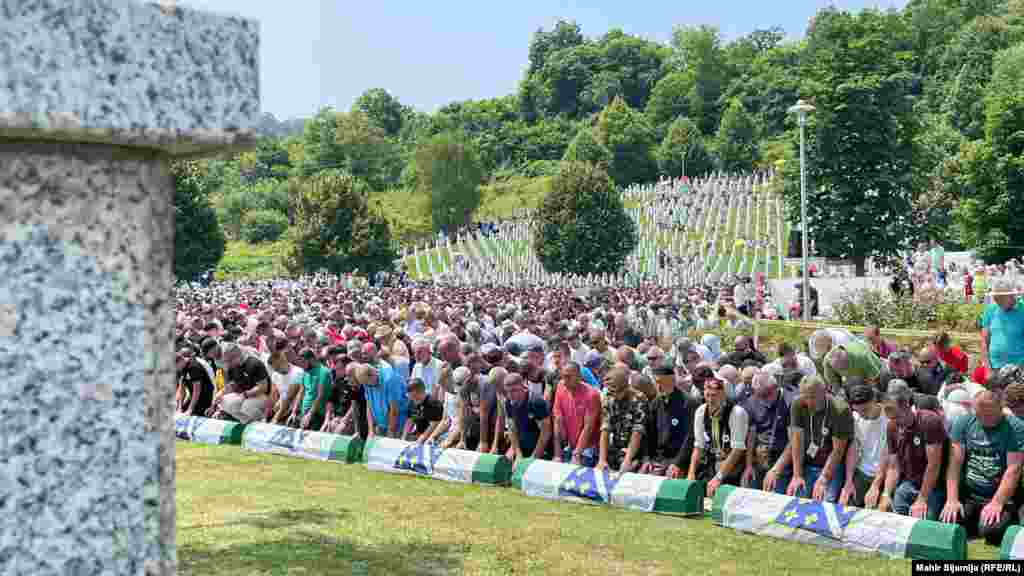 Mourners gather for the religious ceremony before the burial of the genocide victims.