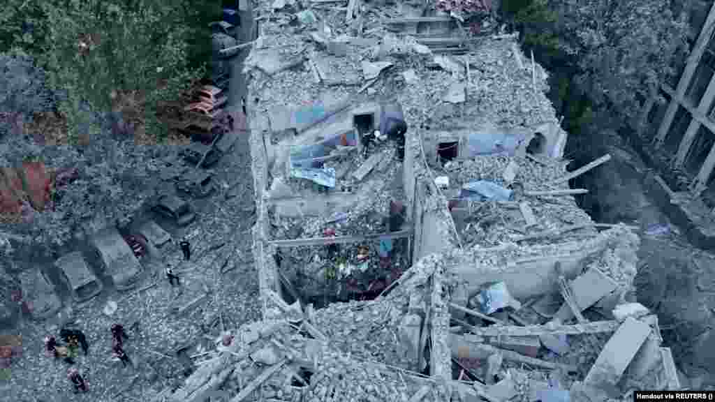 Rescue workers comb through the debris of a residential building in search of survivors.