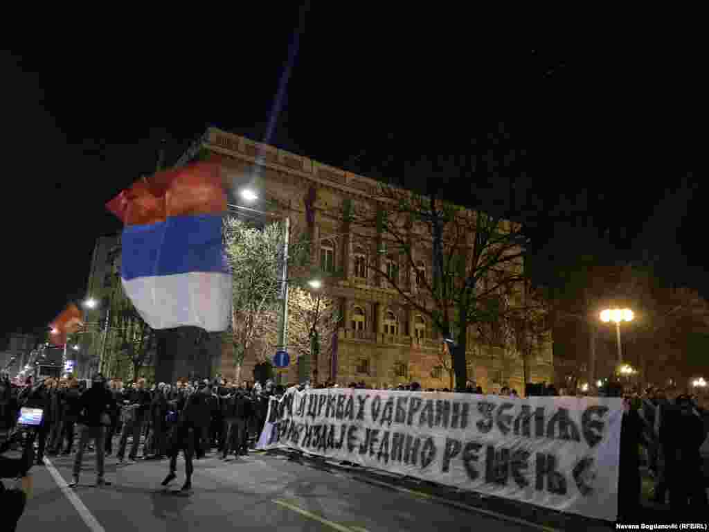 Grupa maskiranih muškaraca, među kojima i oni sa obeležjima ruske paravojne formacije Vagner razvila je transparent "Narod i crkva u odbrani zemlje, protiv izdaje je jedino rešenje".