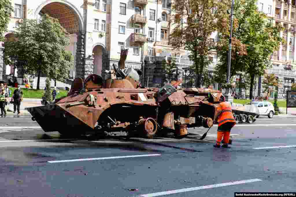 Muncitori de la serviciile comunale curăță bulevardul de rugina și cenușa care se scutură de pe echipamentele militare distruse. Traficul pe Kreșceatik va fi blocat până la 28 august. Kiev, 21 august 2023 &nbsp;