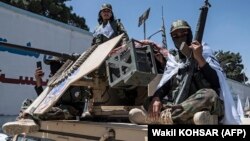تعدادی از طالبان سوار بر یک زرهپوش در کابل 