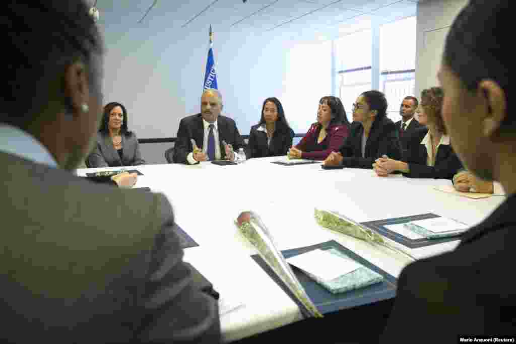 2014 жылғы 24 қазанда АҚШ-тың сол кездегі бас прокуроы Эрик Холдер (ортада) Калифорния бас прокуроы Камала Харриспен бірге "Айыпты деп тану және балама үкімдер" бағдарламасының түлектерімен сөйлесіп отыр. АҚШ-тың Лос-Анджелестегі округтік соты, Калифорния штаты.