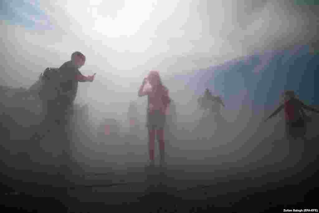 Будапештте адаттан тышкаркы аптапта шаар тургундары фонтандан чачыраган сууга сергип жатат.&nbsp;2023-жылдын жыйы Жердеги метеорологиялык байкоолордун тарыхындагы эң ысык мезгил болду.&nbsp;20-июнь, 2023-жыл. (EPA-EFE/Zoltan Balogh)