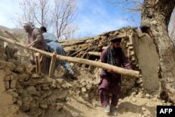 Пакистанда тургундар жер титирөөдө кулаган үйдүн урандыларын тазалап жатышат. Сооч айылы. 22-март, 2023-жыл.