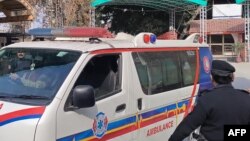 په پېښور کې یو امبولانس په برید کې ژوبل سړی روغتون ته لېږدوي، ورسره نېږدې یو پولیس پهره کوي - انځور له ارشیفه.