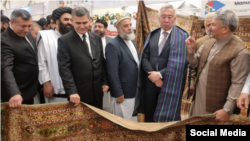 اعضای قزاقستان که در این نمایشگاه حضور یافته اند قالین های دست بافت افغانی را تماشا می کنند. تصویر از صفحه انجمن قالین افغانستان