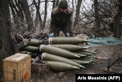 A Ukrainian serviceman prepares 155-millimeter artillery shells near Bakhmut in eastern Ukraine.