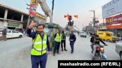 د ډېره اسماعیل خان ښار په څلورلاره کې د ټرافیکو پولیس ګاډو ته د تګ اشاره کوي - د فبرورۍ اوومې انځور.
