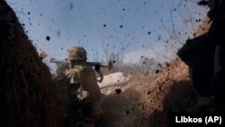 Un militar ucrainean trage cu un lansator de rachete în timpul luptelor cu forțele ruse, pe linia frontului de lângă Bahmut, regiunea Donețk, 24 martie 2023