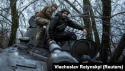 Українські військовослужбовці 4-ї окремої танкової бригади імені Івана Виговського сидять на самохідній гаубиці 2С1 «Гвоздика» перед стрільбою по російських військах біля Куп’янськf