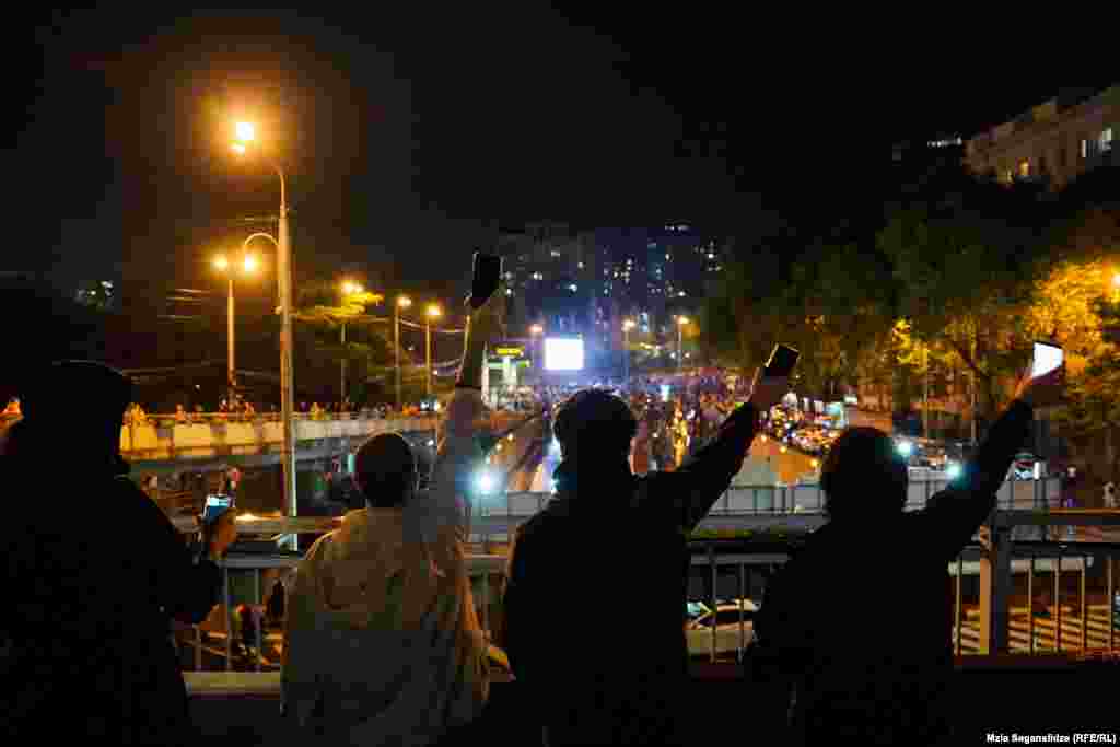 Protesters gesture from an overpass. The bill's opponents refer to the bill as "the Russian law," a reference to the "foreign agent" statute that the Kremlin has employed to stifle dissent.