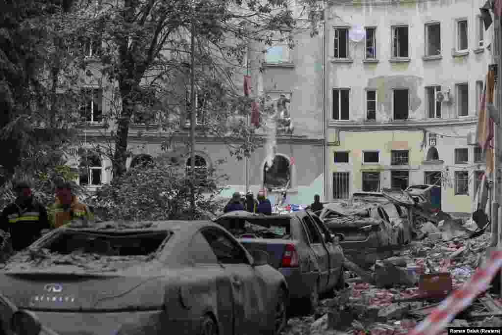 Rescue workers at the scene of a rubble-covered street. Lviv Mayor Andriy Sadovyi said around 60 apartments and 50 cars were damaged.&nbsp;