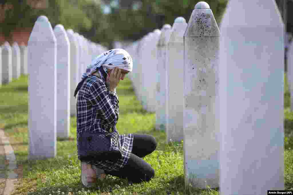 A Bosnian Muslim woman mourns next to the grave of a relative during the commemoration ceremony. Many Serbs deny the extent of the killings, adding to the suffering of the survivors. Bosnian Serb leader Milorad Dodik has previously called the genocide "a fabricated myth."