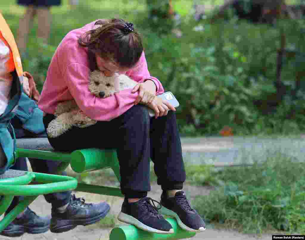 A woman holds her dog following the missile strike.