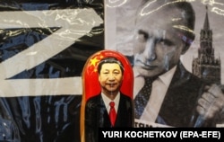 Російська матрьошка з портретом голови Китаю Сі Цзіньпіна перед фотографією очільника Росії Володимира Путіна у сувенірній крамниці в Москві, 20 березня 2023 року