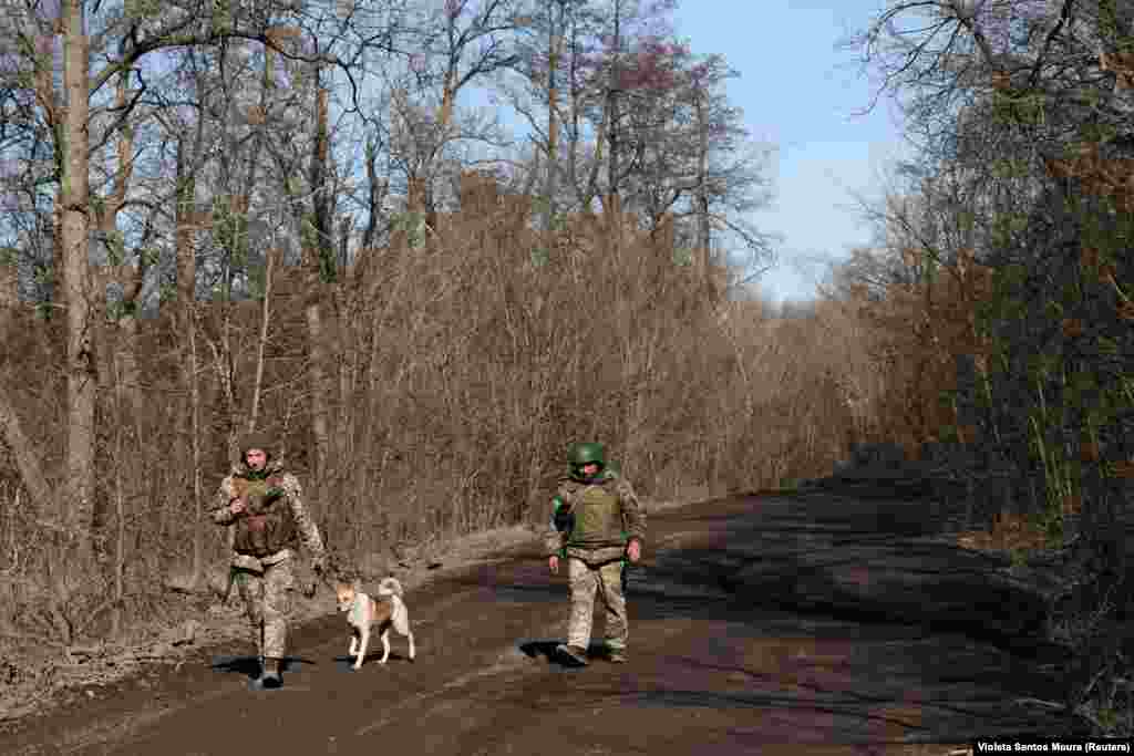 Ukrainian soldiers walk with their unit's dog in an undisclosed location near the frontline town of Kreminna on March 13.