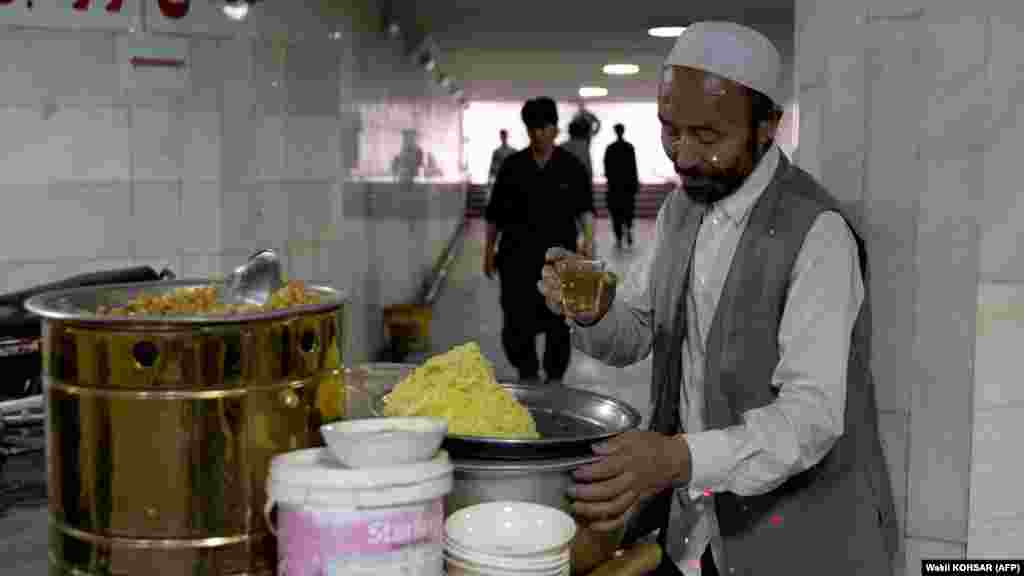 A vendor selling chickpeas takes a tea break while waiting for customers in Kabul. The devastating economic troubles have left many households struggling to buy items needed for Eid celebrations. &nbsp;