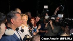 Gabriela Firea și primarul sectorului 4, Daniel Băluță, părăsesc incinta PSD, în mijlocul câtorva zeci de jurnaliști. Drumul de un sfert de oră până la poartă a fost un lung șir de întrebări adresate Gabrielei Firea referitor la eșecul înregistrat la Primăria Capitalei