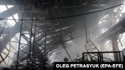 Українські рятувальники працюють на місці ракетного обстрілу складу в Києві, 29 грудня 2023 року