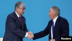 Бывший президент Казахстана Нурсултан Назарбаев (справа) и его преемник Касым-Жомарт Токаев на съезде правящей партии "Нур Отан". Апрель 2019 года