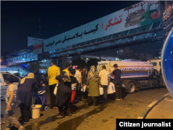 Iranians wait in line for water in Tehran.