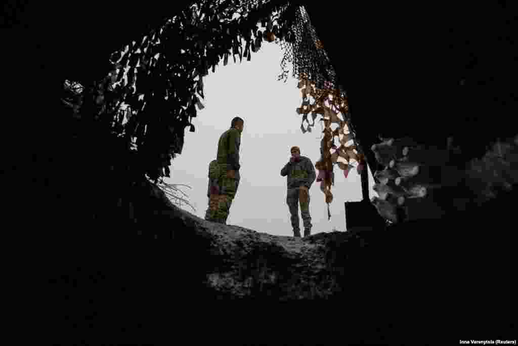 Ukrainian soldiers enjoy a cigarette break near the entrance to their dugout during a lull in fighting near Bakhmut on December 15. Prior to Tarnavskiy's remarks, Kyiv had said its forces had no intention of letting up the fight and would soldier on. &nbsp;