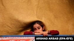 په نوښار کې په ټرک کې سپره یوه افغانه نجلۍ هېواد ته د ستنېدو پر مهال موسکۍ شوې ده - انځور له ارشیفه -