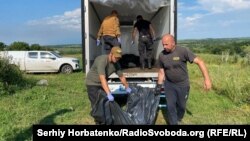 Пошуковці розвантажують мішки з останками для огляду