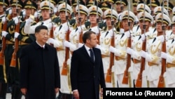 French President Emmanuel Macron (center) reviews the honor guard during a welcome ceremony with Chinese President Xi Jinping outside the Great Hall of the People in Beijing in November 2019.