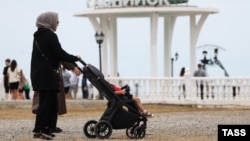 Një ruse duke shëtitur fëmijën e saj diku në Rusi.