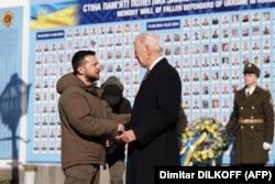 Президент України Володимир Зеленський і президент США Джо Байден біля Стіни пам'яті із тисячами фотографій українських воїнів, загиблих на російсько-українській війні. Київ, 20 лютого 2023 року