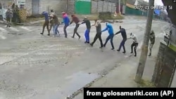 4 березня 2022 року. Кадр із камери відеоспостереження: російські солдати ведуть 9 людей під дулами автоматів у свій штаб в окупованій Бучі. Після катувань їх стратять.