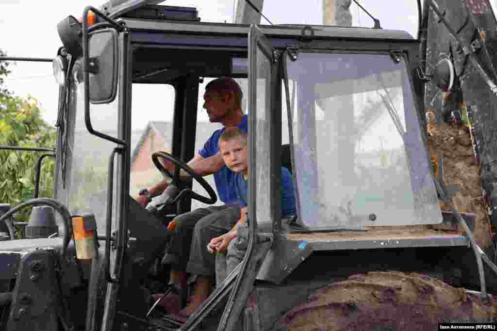 Молодший син Альони &ndash; десятирічний Толя сидить у кабіні із сусідом, який керує трактором. Він допомагає розбирати завали свого будинку