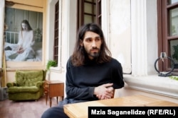 ნიკიტა მის მიერ გადაღებული ფოტოს ფონზე. ფოტოს ჰქვია "BAD TRIPS" და ის ჯერ კიდევ რუსეთში ცხოვრების დროს აქვს გადაღებული.