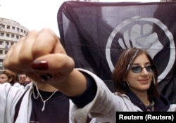 Studentja tregon grushtin e saj që është përshëndetje tradicionale e organizatës OTPOR (Rezistenca).