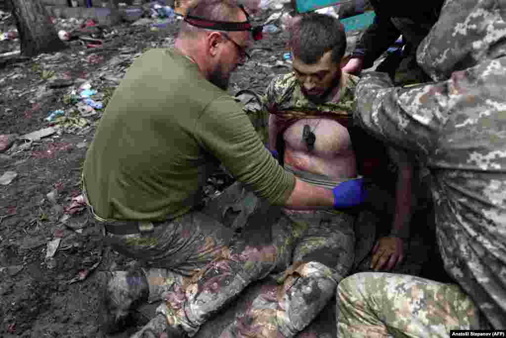 Military paramedics treat a wounded Ukrainian soldier. "Each day we resist here gives more opportunities for other units to prepare for a counterattack," Philosopher added. "Our vulnerability is that we are starved for shells."