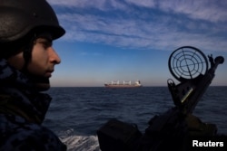 Український морський прикордонник спостерігає за судном, яке вийшло з порту України і прямує в Чорне море. Лютий 2024 року