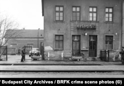 Тот же полицейский, что и на фотографии выше, направляет пистолет на другого мужчину в форме с автоматом Калашникова