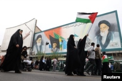 ირანელ ქალს უჭირავს პალესტინის დროშა პალესტინელების მხარდასაჭერი მიტინგის დროს თეირანში. ირანი, 2023 წლის 13 ოქტომბერი.