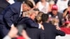Candidatul republican la președinție, fostul președinte Donald Trump, este ajutat să coboare de pe scenă de agenții Serviciului Secret al SUA în timpul mitingului din orașul Butler, Pennsylvania, 13 iulie 2024.