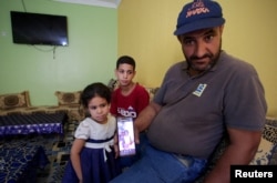 Иман Хелифтің әкесі қызының кішкентай кездегі фотосын көрсетіп отыр. Алжир, 2 тамыз 2024 жыл.