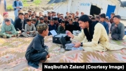 نقیت الله ځلاند با تعدادی از اطفال که قرار است شامل مکتب شوند
