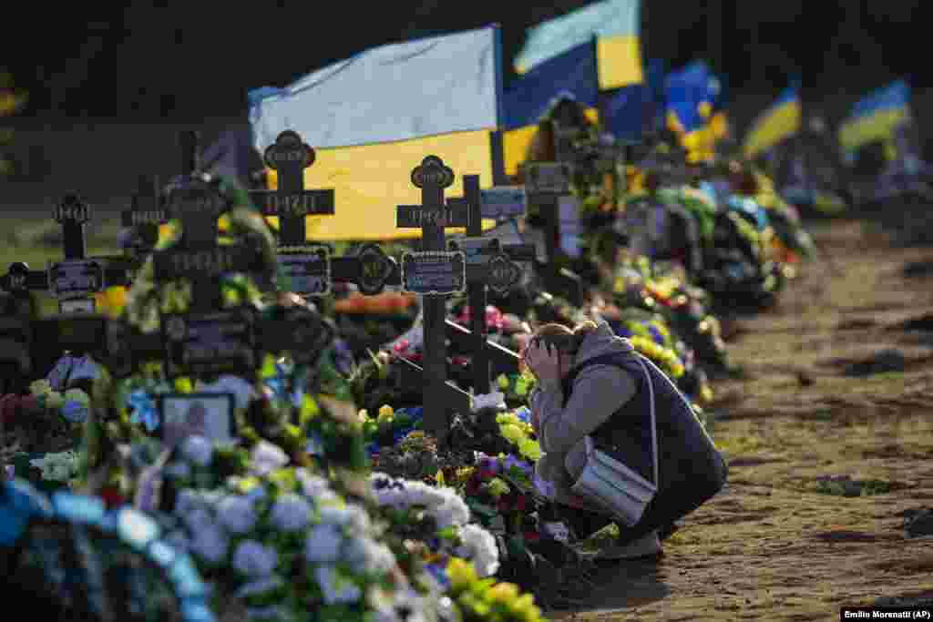 Într-un cimitir din Mykolaiv, în sudul Ucrainei, în octombrie 2022, o femeie plânge la mormântul singurului ei fiu, soldat ucis de un bombardament rusesc.