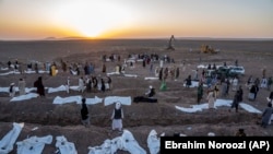 د اکتوبر پر نهمه د هرات ولایت زنده جان په ولسوالۍ کې په زلزله کې د وژل شویو مړي خاورو ته د سپارلو په مهال.