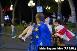 აქციის მონაწილეებს დაშავებული დემონსტრანტი მიჰყავთ სასწრაფო დახმარებისკენ. 3 მაისი, 3034