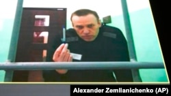 Russian opposition leader Alexei Navalny is seen on a TV screen as he appears in a video link provided by the Russian Federal Penitentiary Service during a hearing on June 22. 