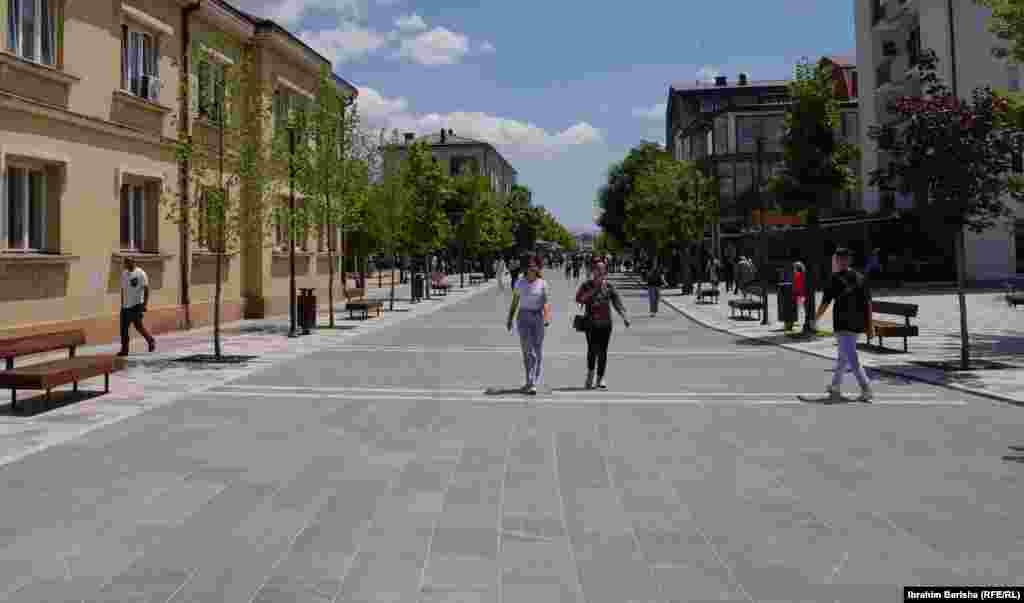 Djeca trče pored britanskog tenka nakon što je stigao u Podujevo 18. juna 1999. godine. Trg je danas proširen svježe zasađenim drvećem.