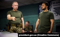 На той час командувач Сухопутних військ ЗСУ генерал-полковник Олександр Сирський (ліворуч) доповідає президенту України Володимиру Зеленському про ситуацію на Бахмутському напрямку. Донеччина, 5 вересня 2023 року