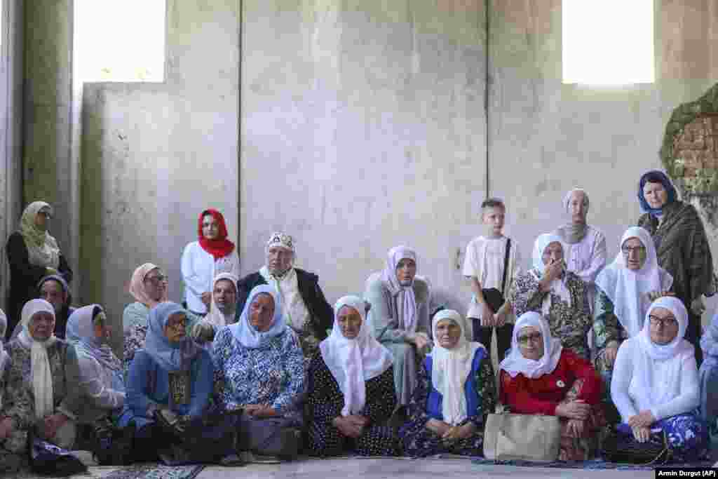 Muslim women pray next to 30 coffins containing the remains of their loved ones in Potocari, Bosnia-Herzegovina, on July 9. Their family members were&nbsp;victims of the 1995 Srebrenica genocide. The remains were to be buried on July 11 following a commemorative ceremony marking the 28th anniversary of the massacre, Europe's only&nbsp;acknowledged genocide since World War II.